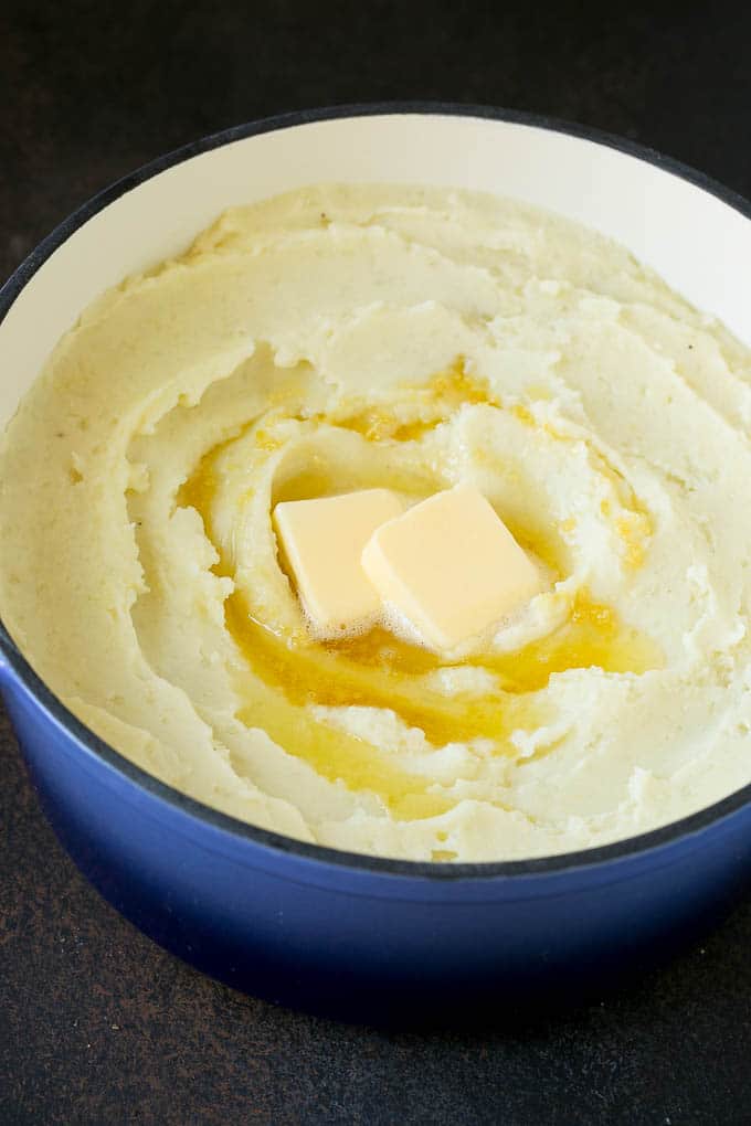 Garlic Mashed Potatoes Recipe #garlic #potatoes #mashedpotatoes #sidedish #dinner #thanksgiving #ezlod Spuds with melted butter on top.