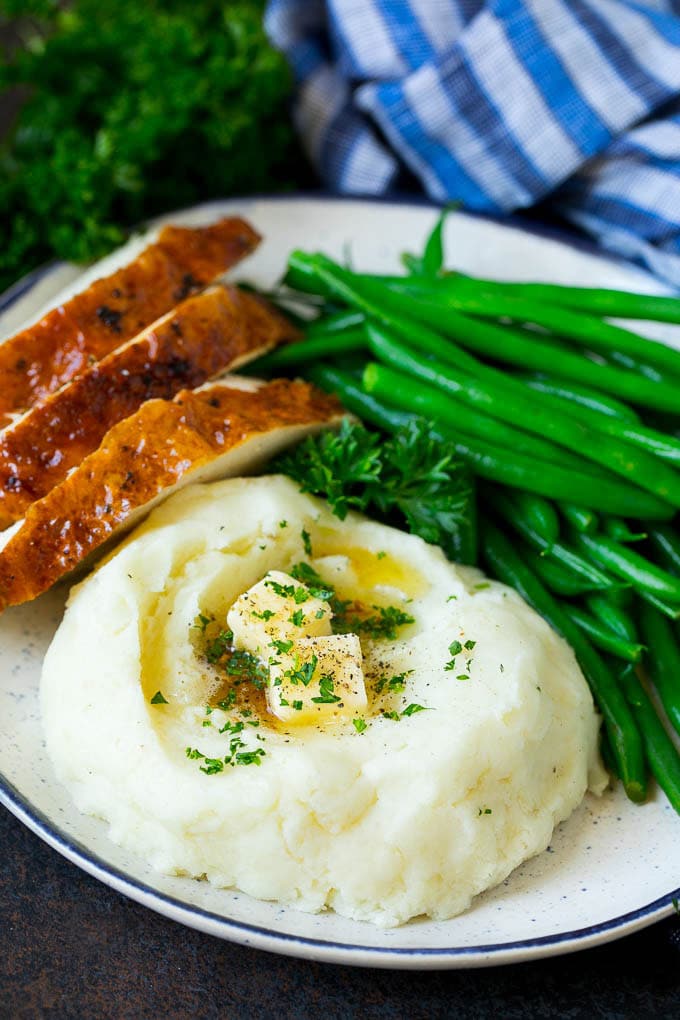 Garlic Mashed Potatoes Recipe #garlic #potatoes #mashedpotatoes #sidedish #dinner #thanksgiving #ezlod A plate with garlic mashed potatoes, green beans and sliced turkey.