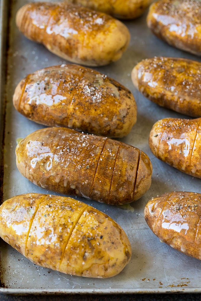 Hasselback Potatoes Recipe #potatoes #bacon #sidedish #cheese #dinner #ezlod Potatoes on a sheet pan coated in olive oil and butter.