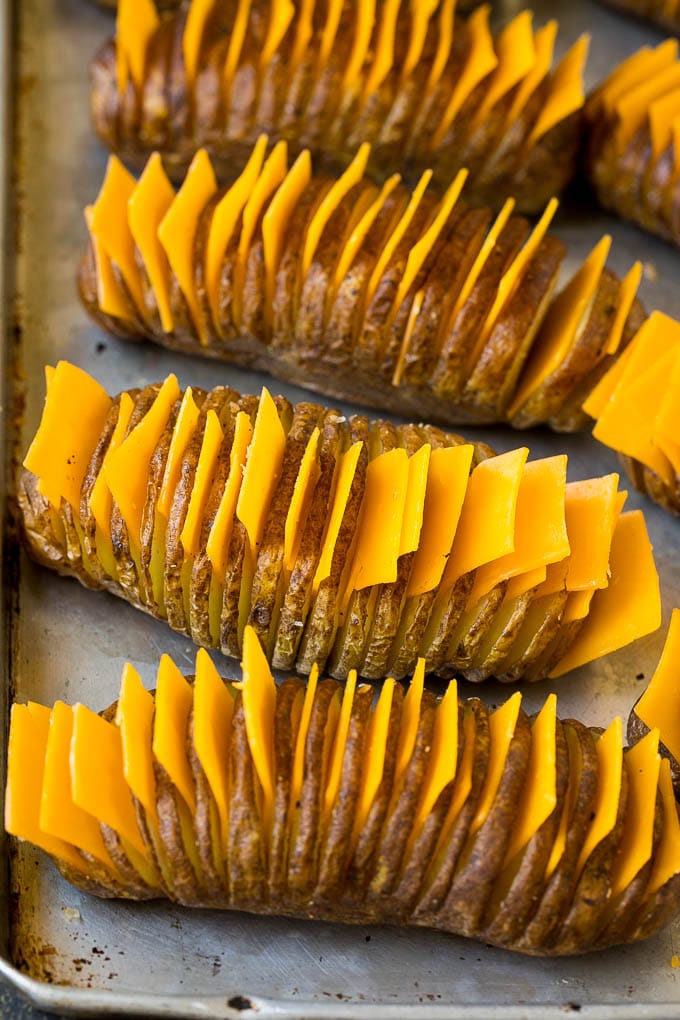 Hasselback Potatoes Recipe #potatoes #bacon #sidedish #cheese #dinner #ezlod Thinly sliced potatoes with slices of cheese in between the cuts.