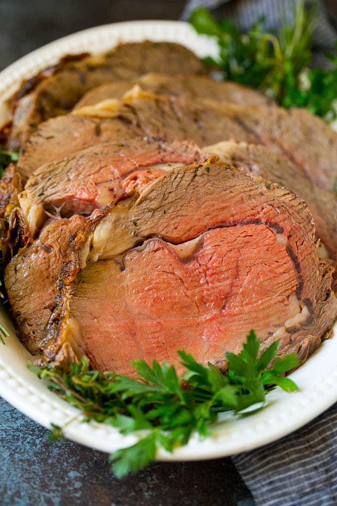 Prime Rib Recipe #primerib #beef #roast #dinner #thanksgiving #christmas #keto #lowcarb #ezlod Sliced slow roasted prime beef on a serving platter.