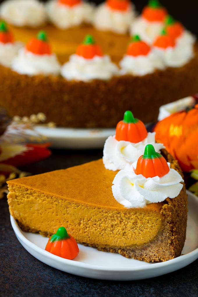 Pumpkin Pie Cheesecake Recipe | Pumpkin Cheesecake #cake #cheesecake #pumpkin #fall #thanksgiving #dessert #ezlod A slice of pumpkin pie cheesecake garnished with whipped cream.