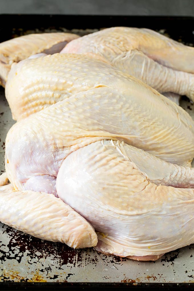 Spatchcock Turkey | Roasted Turkey | Thanksgiving Turkey #turkey #thanksgiving #dinner #fall #christmas #ezlod A flattened whole turkey on a sheet pan.