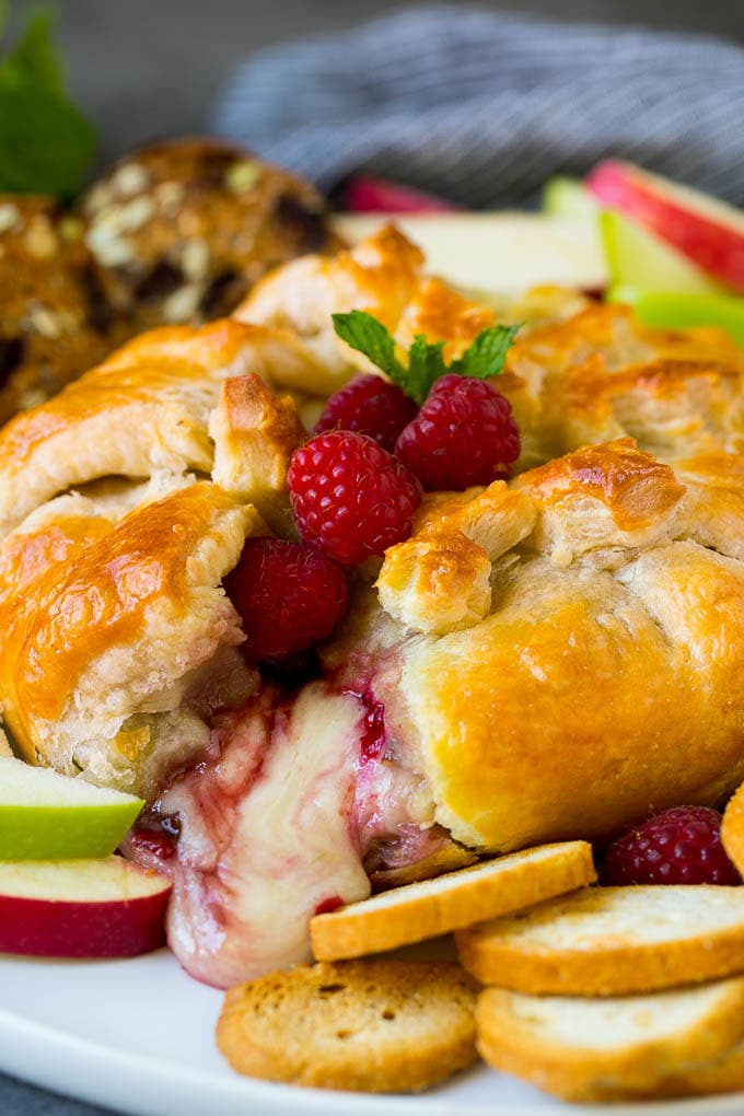 Baked Brie Recipe | Pastry Wrapped Brie #brie #cheese #appetizer #pecans #raspberries #ezlod Baked brie cut open with cheese spilling out.