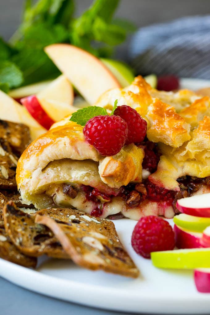 Baked Brie Recipe | Pastry Wrapped Brie #brie #cheese #appetizer #pecans #raspberries #ezlod A cross section of baked brie filled with raspberries and pecans.