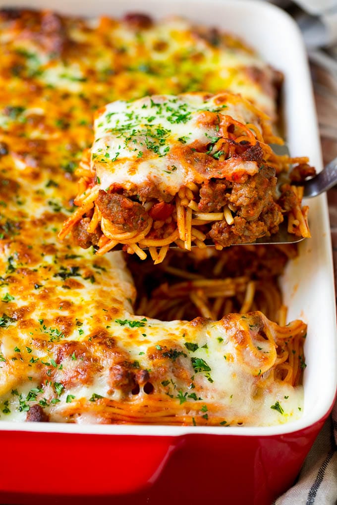 Baked Spaghetti Recipe | Baked Pasta #spaghetti #pasta #cheese #casserole #beef #sausage #dinner #ezlod A spatula holding up a serving of baked spaghetti.