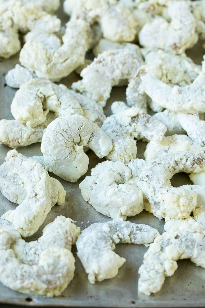 Bang Bang Shrimp Recipe | Fried Shrimp #shrimp #appetizer #dinner #ezlod #copycatrecipe Shrimp coated in cornstarch on a sheet pan.