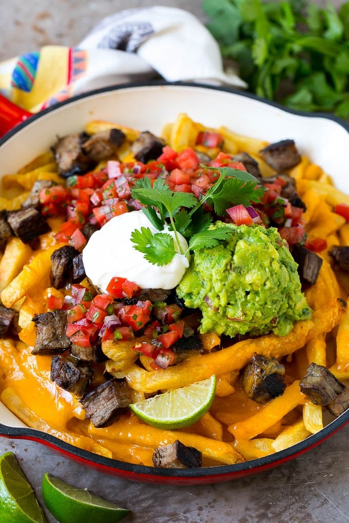 Carne Asada Fries Recipe | Steak Fries #fries #frenchfries #steak #salsa #avocado #cheese #dinner #appetizer #ezlod Carne asada fries topped with melted cheese, steak, salsa and guacamole.