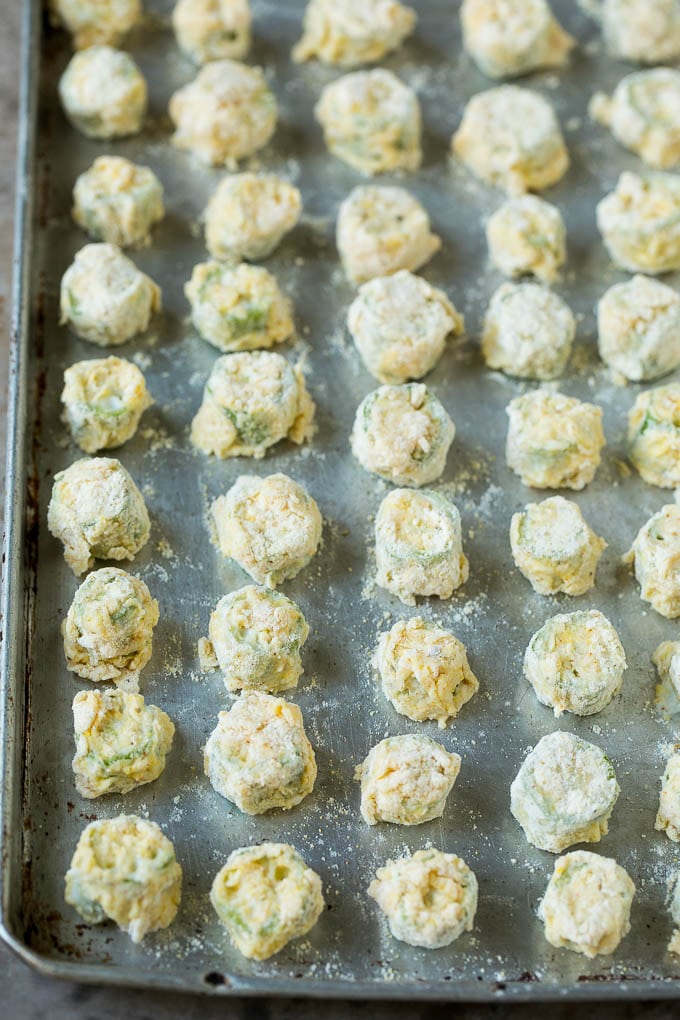Fried Okra Recipe #okra #appetizer #sidedish #ezlod Breaded okra slices on a sheet pan.