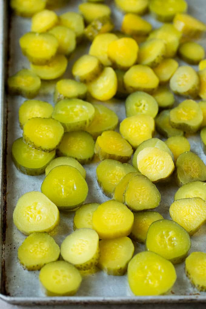 Fried Pickles Recipe #pickles #appetizer #snack #ezlod Sliced dills on a sheet pan.