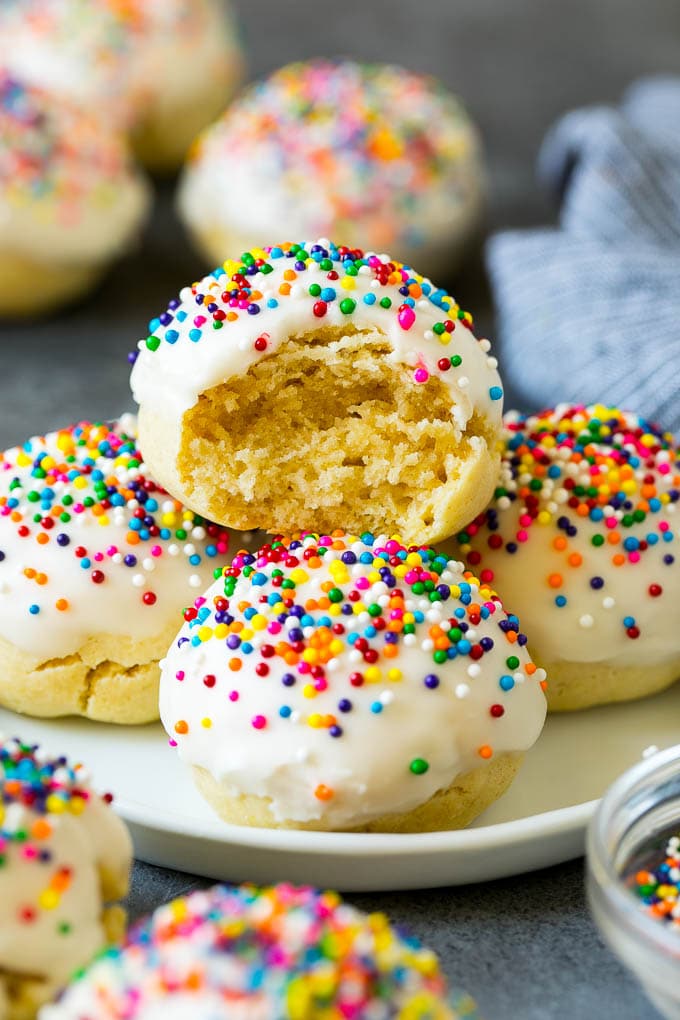 Italian Cookies Recipe | Almond Cookies #cookies #italianfood #frosting #sprinkles #baking #christmas #ezlod A plate of Italian cookies with a bite taken out of one.