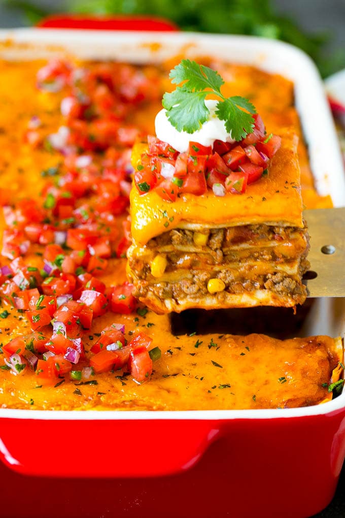 Mexican Lasagna Recipe | Mexican Casserole #mexican #lasagna #groundbeef #beans #dinner #cheese #ezlod A spatula serving up a portion of Mexican lasagna.