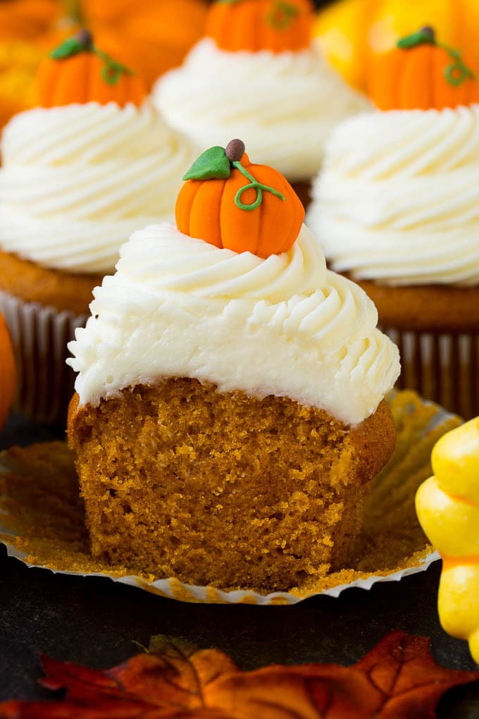 Pumpkin Cupcakes Recipe | Pumpkin Cake #cake #cupcakes #pumpkin #frosting #baking #fall #thanksgiving #ezlod A pumpkin cupcake cut in half, surrounded by fall decorations.