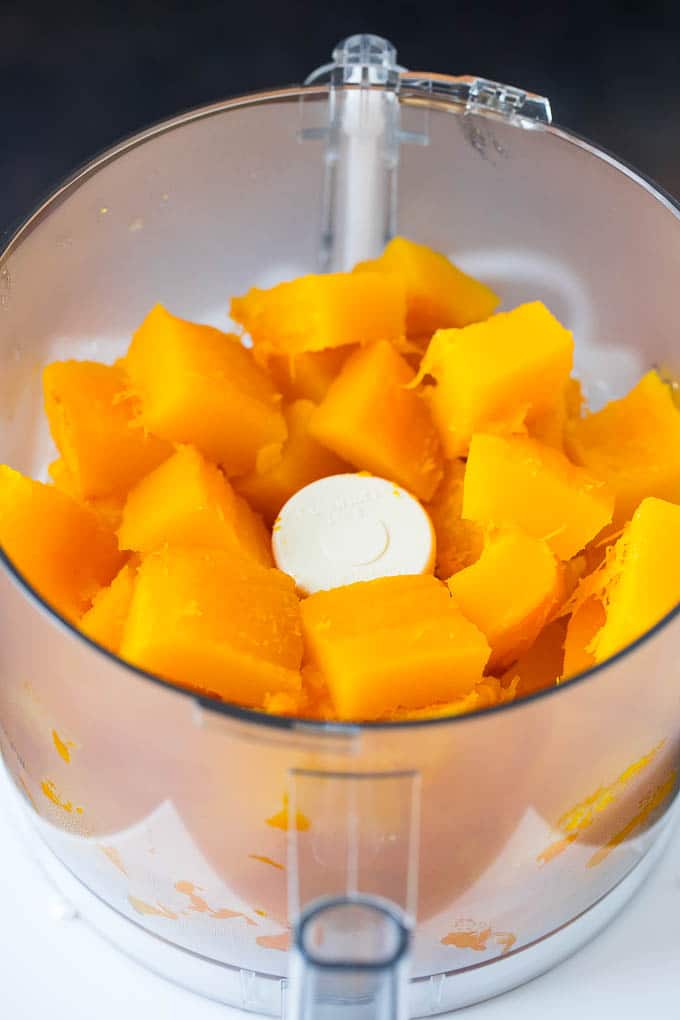 Pumpkin Puree Recipe #pumpkin #baking #fall #thanksgiving #ezlod Cubes of pumpkin in a food processor.