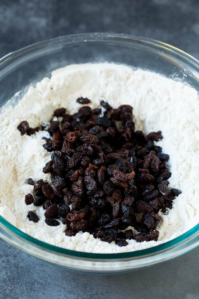 Irish Soda Bread Recipe #bread #baking #stpatricksday #sidedish #ezlod Flour, sugar, butter, baking powder and raisins in a mixing bowl.