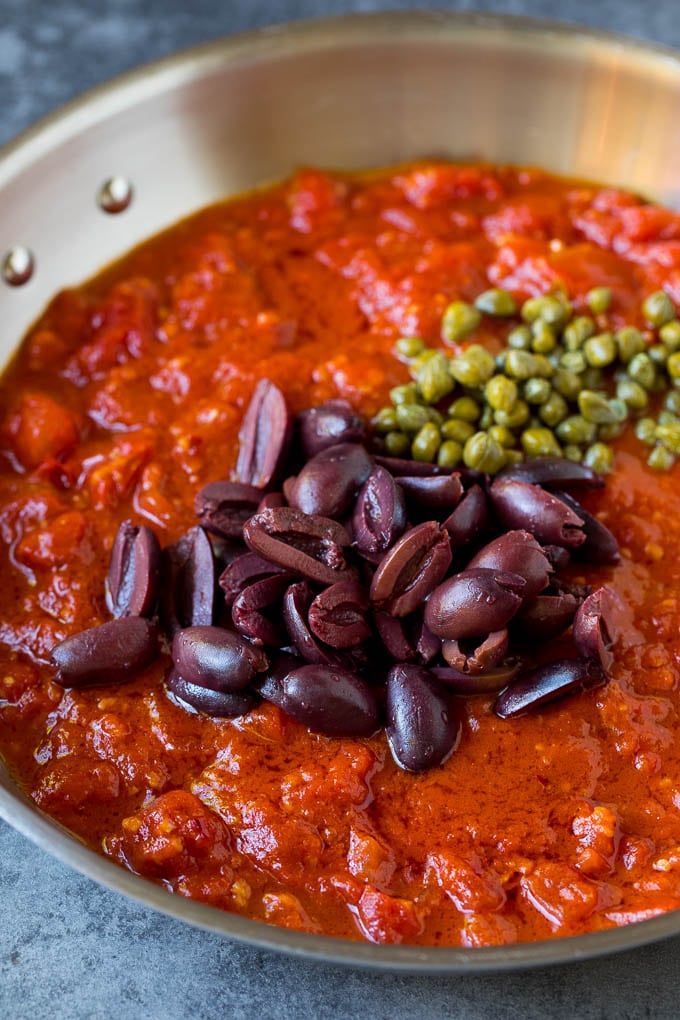 Pasta Puttanesca Recipe #pasta #tomatoes #olives #italianfood #dinner #ezlod Tomato sauce with olives and capers on top.