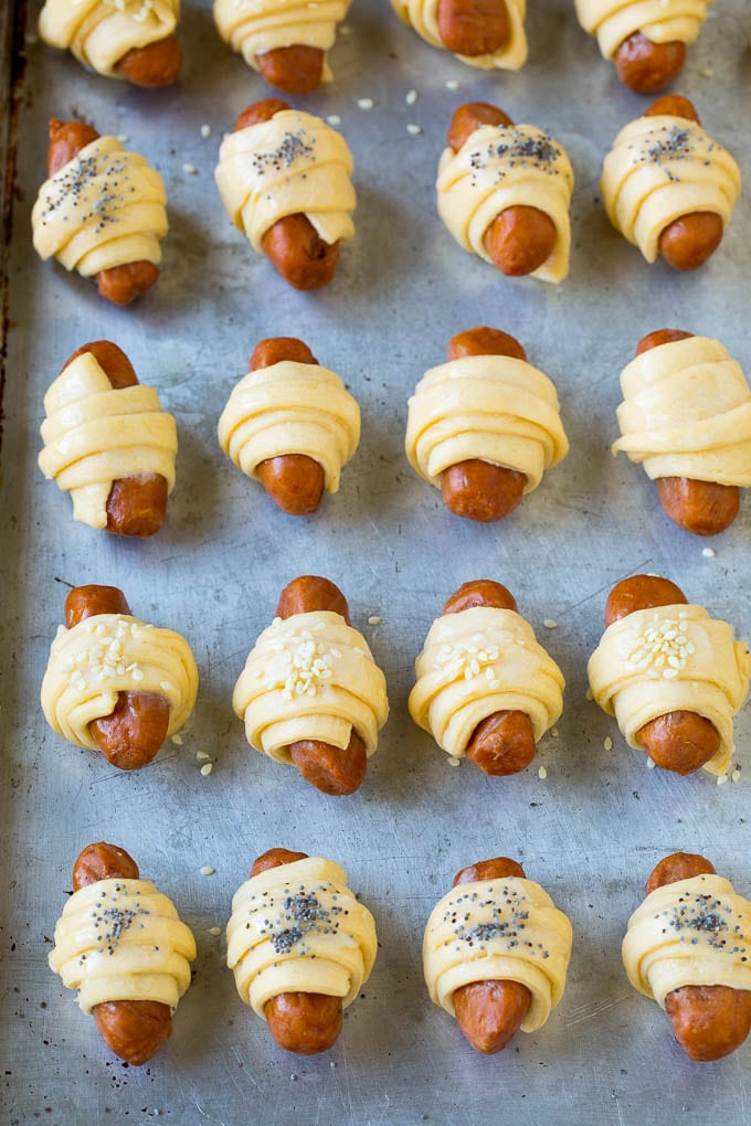 Pigs in a Blanket Recipe #hotdogs #appetizer #snack #comfortfood #ezlod Mini hot dogs wrapped in crescent dough and topped with seeds.
