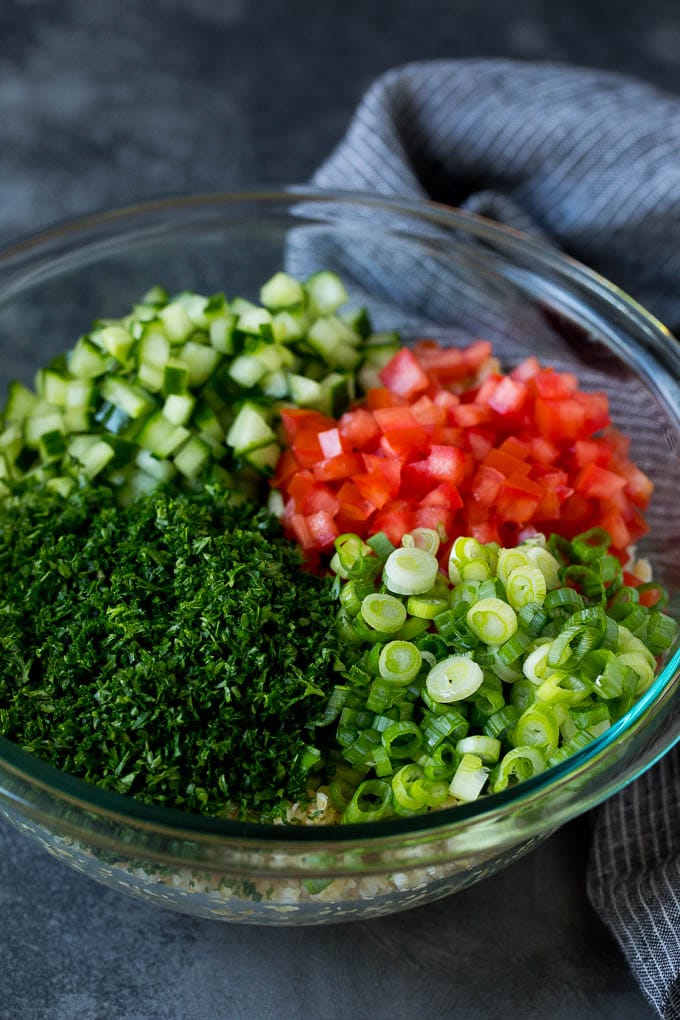 Tabbouleh Salad | Tabouli #salad #wheat #tomatoes #cucumber #healthy #sidedish #dinner #ezlod A bowl of bulgur topped with herbs, tomatoes and cucumber.