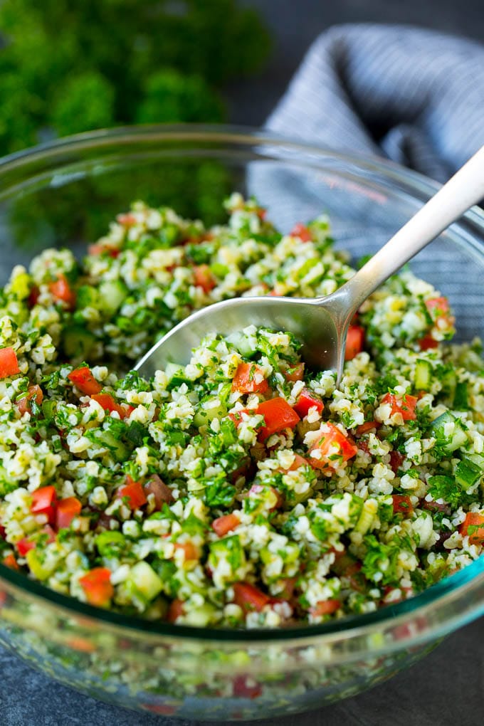 Tabbouleh Salad | Tabouli #salad #wheat #tomatoes #cucumber #healthy #sidedish #dinner #ezlod A bowl of tabbouleh with a serving spoon in it.