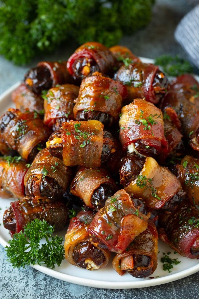 Bacon Wrapped Dates #appetizer #bacon #dates #cheese #ezlod A plate of bacon wrapped dates stuffed with goat cheese.