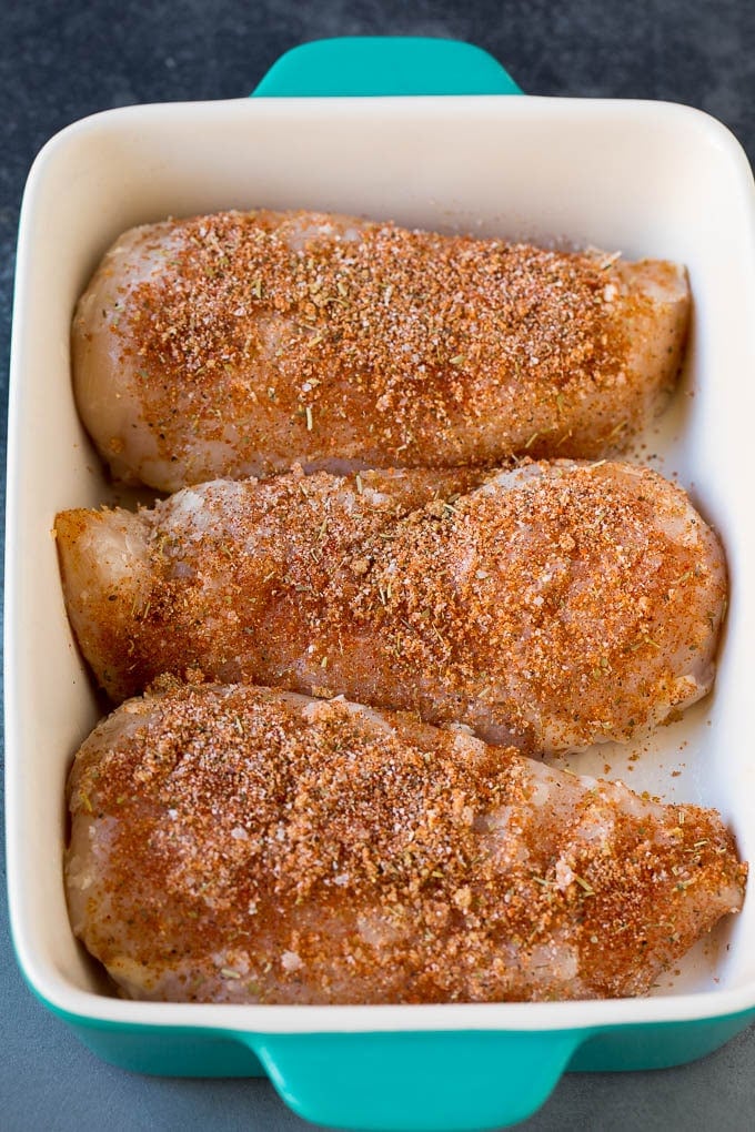 Baked Chicken Breast Recipe #chicken #dinner #ezlod Chicken coated in seasonings in a baking dish.