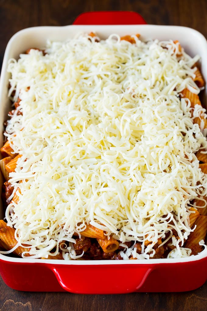 Baked Rigatoni Pasta #pasta #dinner #italianfood #groundbeef #ezlod #casserole A pan of pasta in sauce topped with shredded cheese.