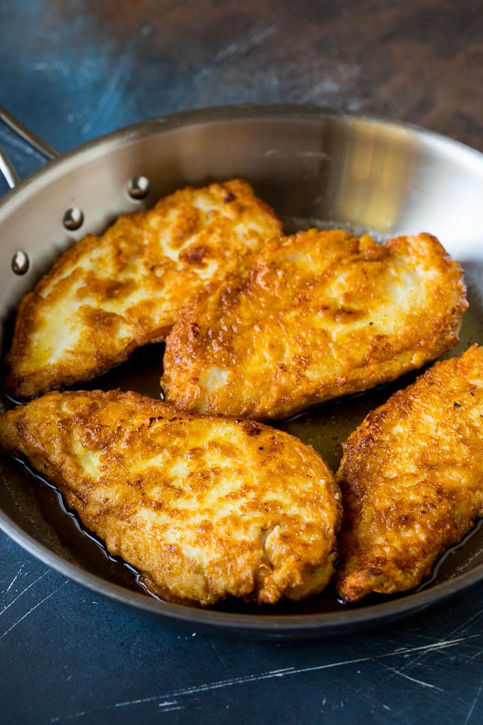 Chicken Francese Recipe #chicken #lemon #dinner #ezlod Battered and pan fried chicken cutlets in a pan.