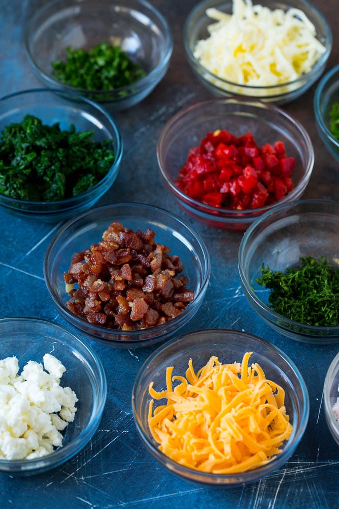Mini Quiche Recipe #eggs #breakfast #brunch #appetizer #ezlod Bowls of assorted flavorings for quiche.