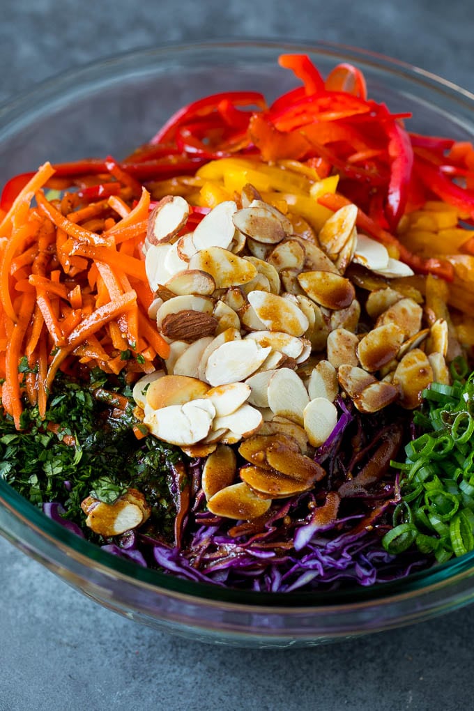 Asian Slaw Recipe #salad #slaw #sidedish #ezlod Homemade dressing poured over Asian coleslaw.