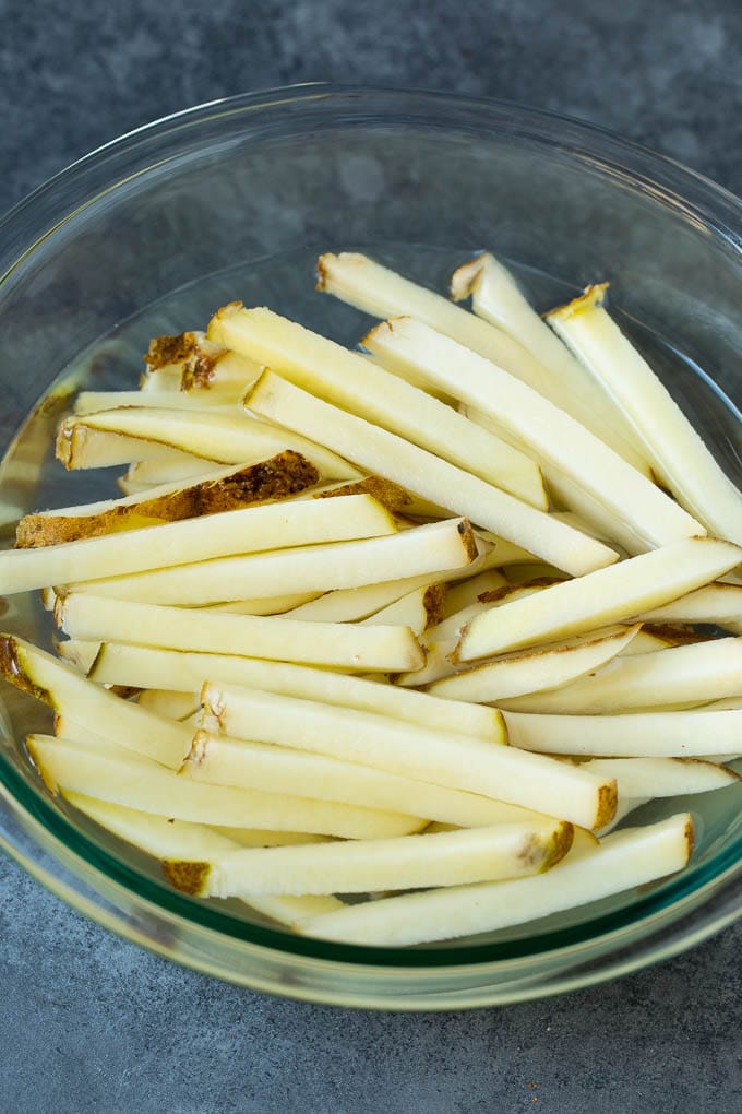 Homemade French Fries Recipe #potatoes #fries #dinner #ezlod Sliced potato sticks in a bowl of water.