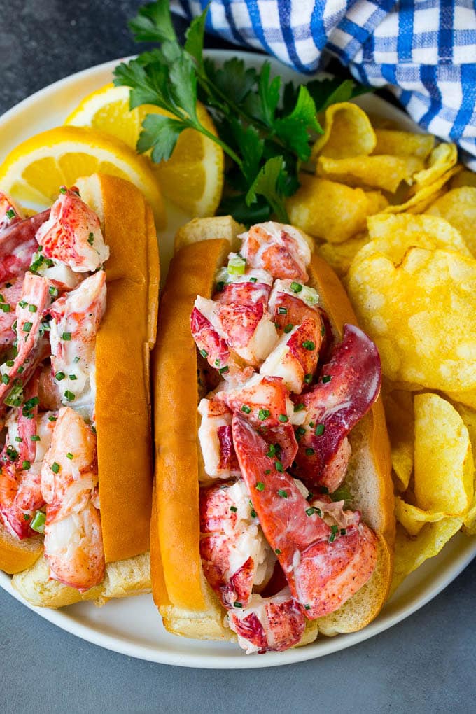 Lobster rolls stuffed with creamy lobster salad in a toasted bun. #lobster #ezlod A lobster roll filled with a creamy seafood mixture and served with chips.