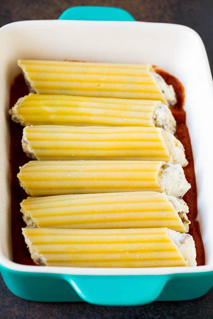 Baked Manicotti Recipe #pasta #cheese #dinner #ezlod Pasta tubes stuffed with sausage and cheese in a baking dish.