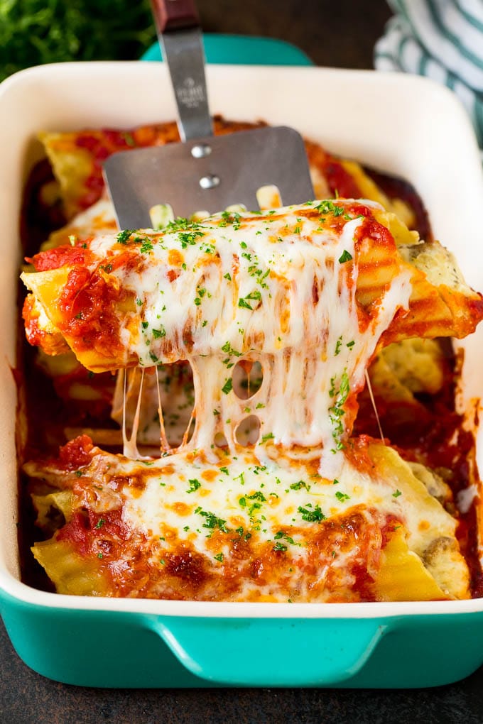 Baked Manicotti Recipe #pasta #cheese #dinner #ezlod A spatula serving up a portion of baked manicotti pasta.