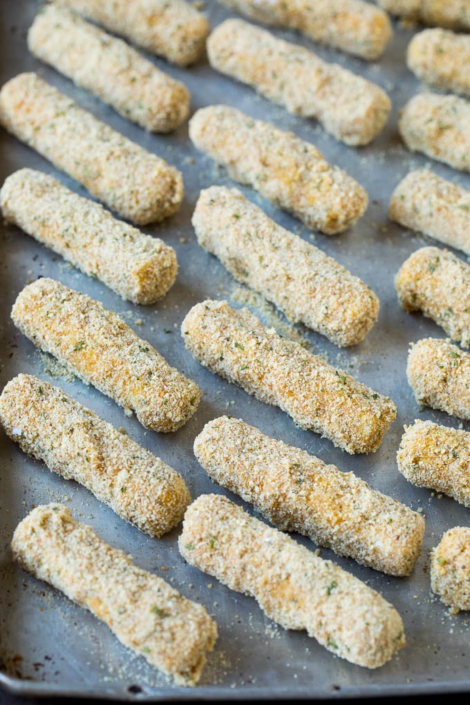 Mozzarella Sticks Recipe #cheese #appetizer #ezlod Breaded cheese on a baking pan.