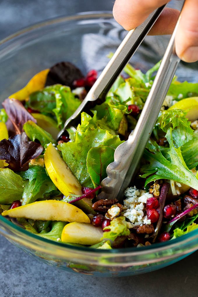 Pear Salad Recipe #salad #pears #fall #winter #dinner #ezlod Tongs serving up a portion of pear salad.