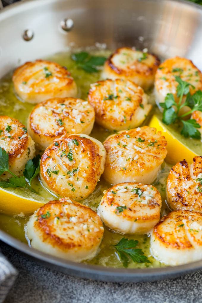 Seared scallops with a garlic and herb butter sauce. An easy and elegant dinner! #seafood #dinner #ezlod Seared scallops in a lemon garlic sauce with fresh parsley.