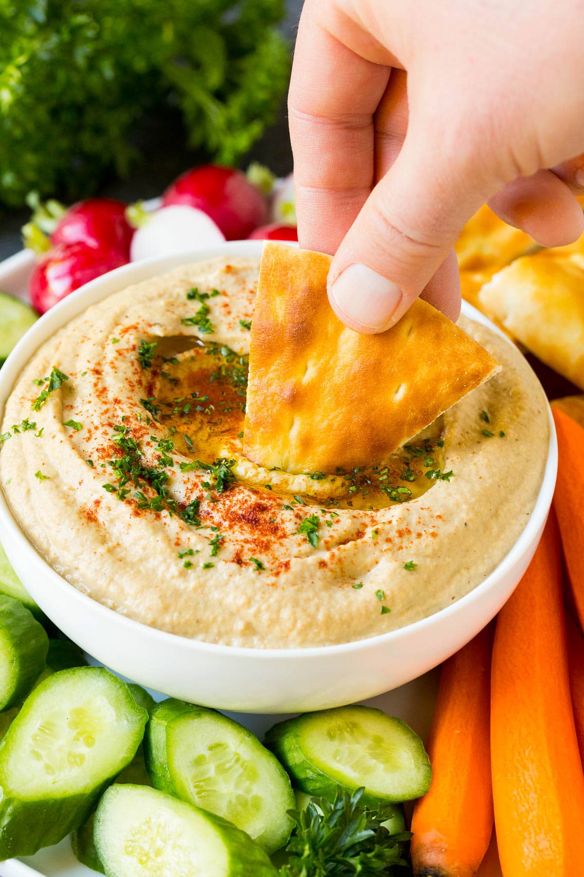 Baba Ganoush Recipe | Eggplant Dip #eggplant #appetizer #dip #healthy #glutenfree #lowcarb #ezlod A hand dipping pita bread into baba ganoush.