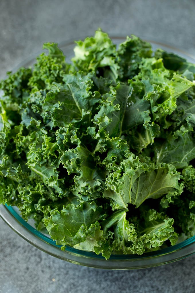 Sauteed kale flavored with olive oil and garlic, a quick and easy side dish! #kale #ezlod Chopped kale in a mixing bowl.