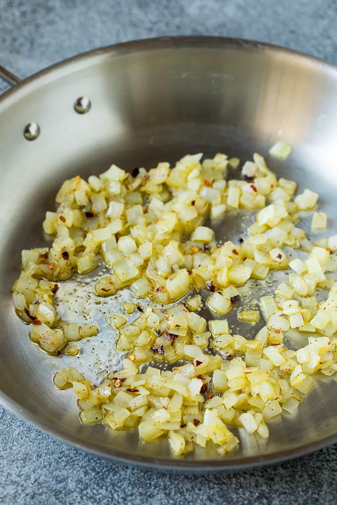 Sauteed kale flavored with olive oil and garlic, a quick and easy side dish! #kale #ezlod Sauteed onions in a skillet.
