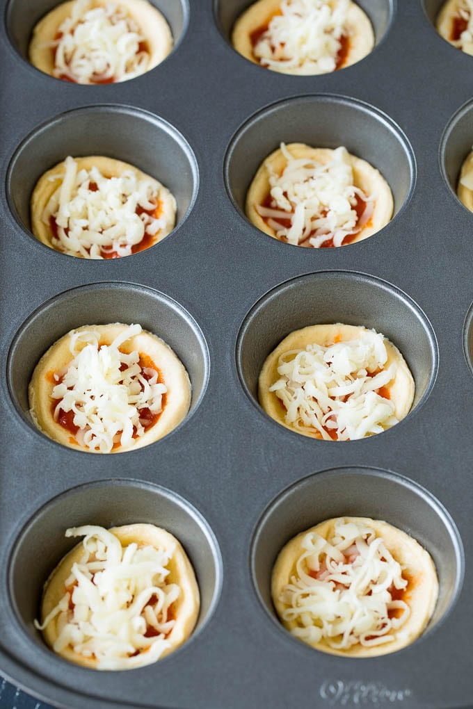 Mini pizzas topped with pepperoni are a fun and easy appetizer option. #pizza #ezlod #appetizer Circles of dough topped with pizza sauce and shredded cheese.