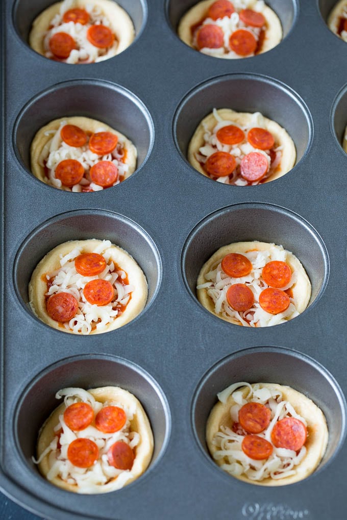 Mini pizzas topped with pepperoni are a fun and easy appetizer option. #pizza #ezlod #appetizer Dough topped with sauce, cheese and mini pepperoni.