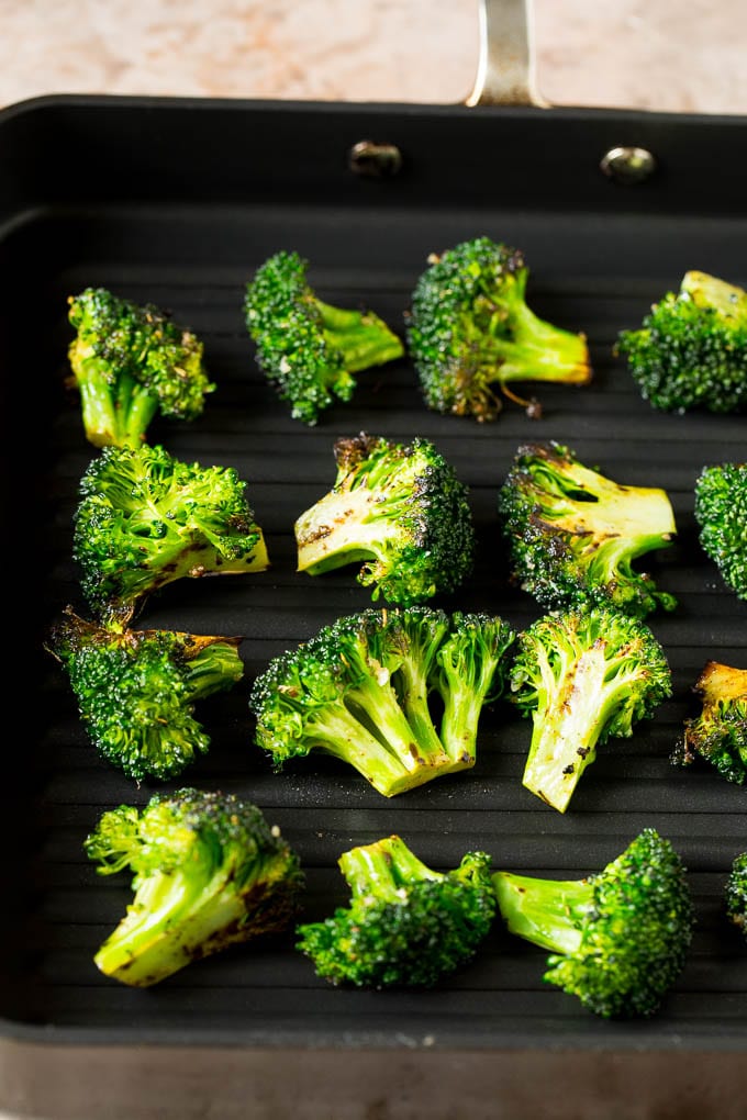 Grilled broccoli is packed with flavor and is a colorful and healthy side dish! #broccoli #ezlod Broccoli florets on a grill pan.