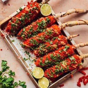 A tray with several elotes made with Flaming Hot Cheetos.