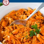 This crock pot buffalo chicken is chicken breasts cooked to tender perfection in a mixture of hot sauce, ranch seasoning and butter.