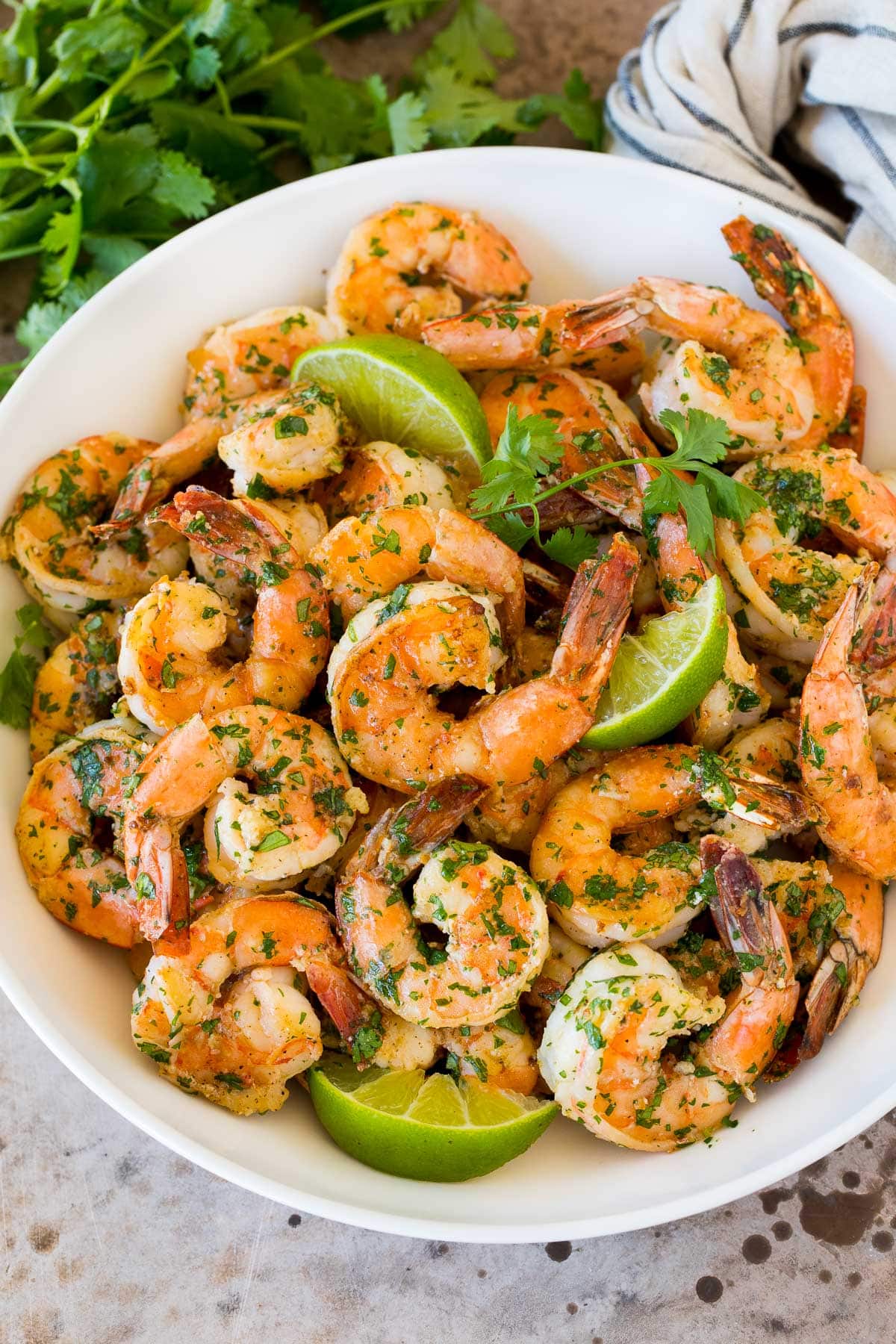 Cilantro Lime Shrimp | Seared Shrimp | Mango Salsa #salsa #shrimp #dinner #appetizer #ezlod A serving bowl of cilantro lime shrimp with lime wedges in it.