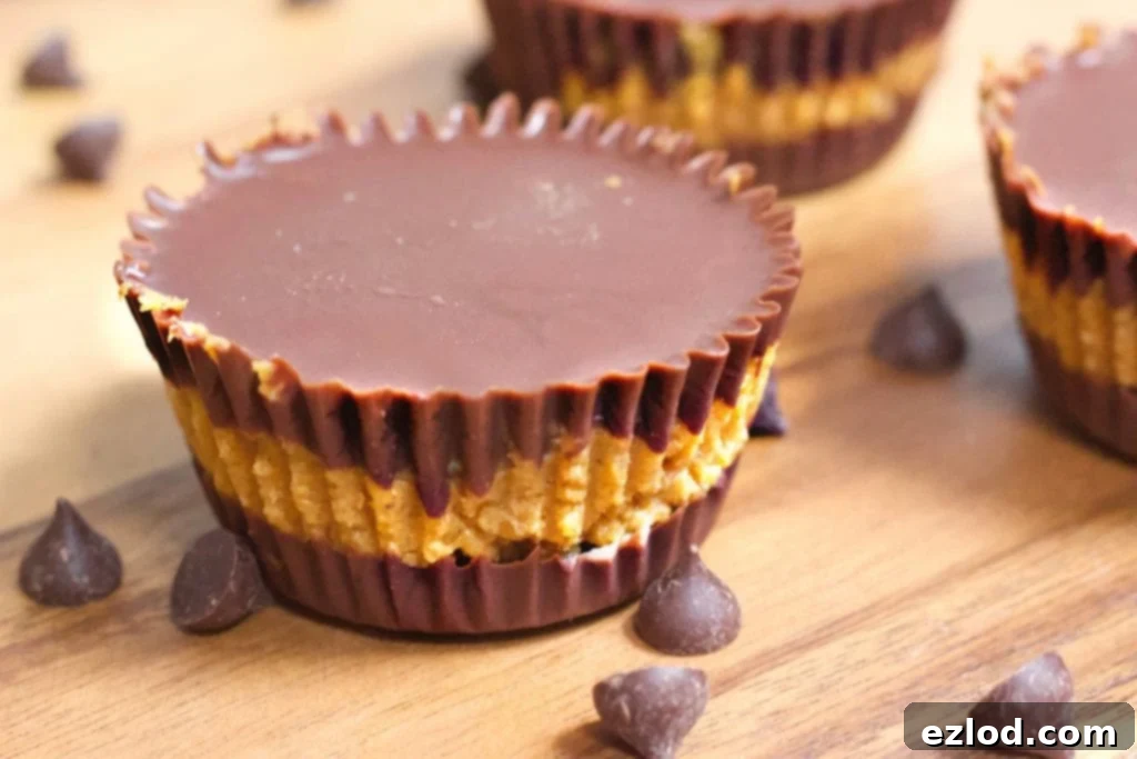 Homemade pumpkin chocolate cups on a wooden table, showcasing a simple, clean, and delicious fall dessert recipe.