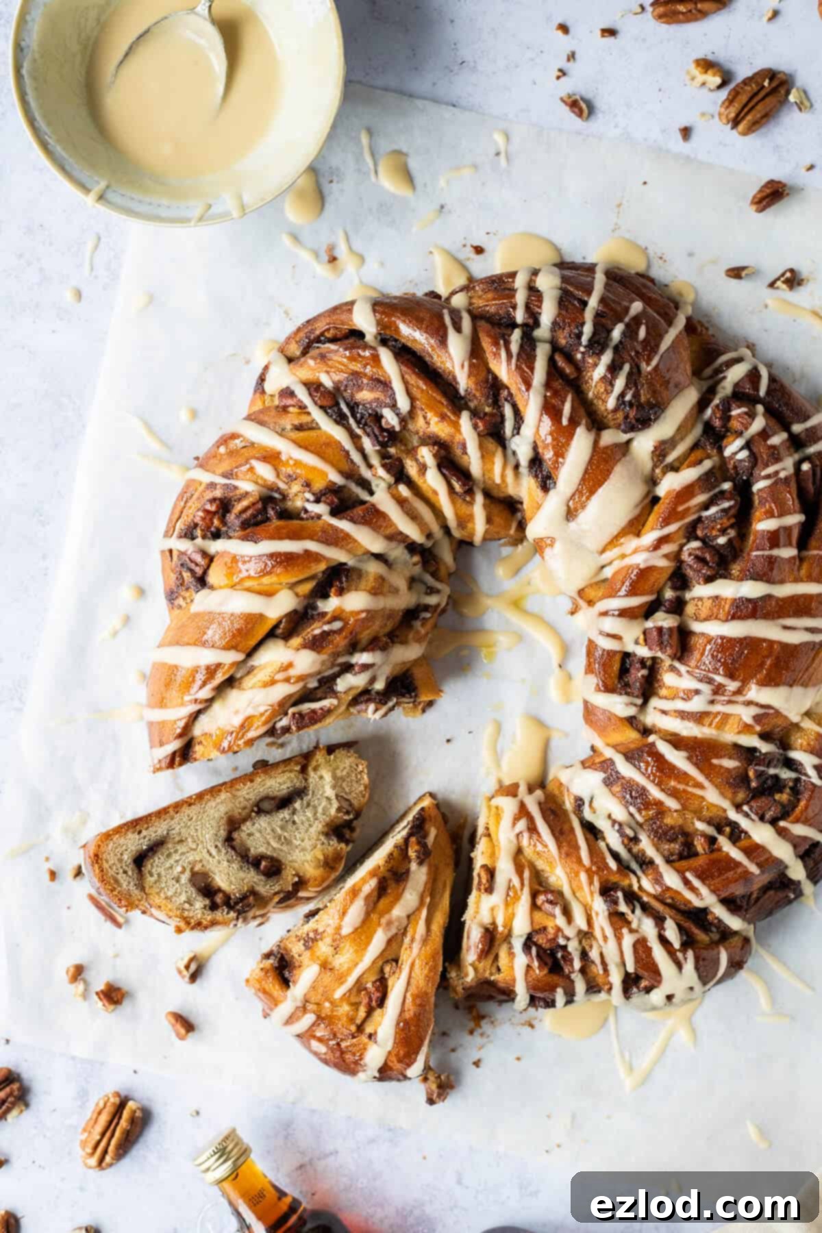 A beautiful close-up of a vegan maple pecan bread wreath, sliced to reveal the tempting layers of pecan and cinnamon filling, highlighting its soft texture and inviting aroma.