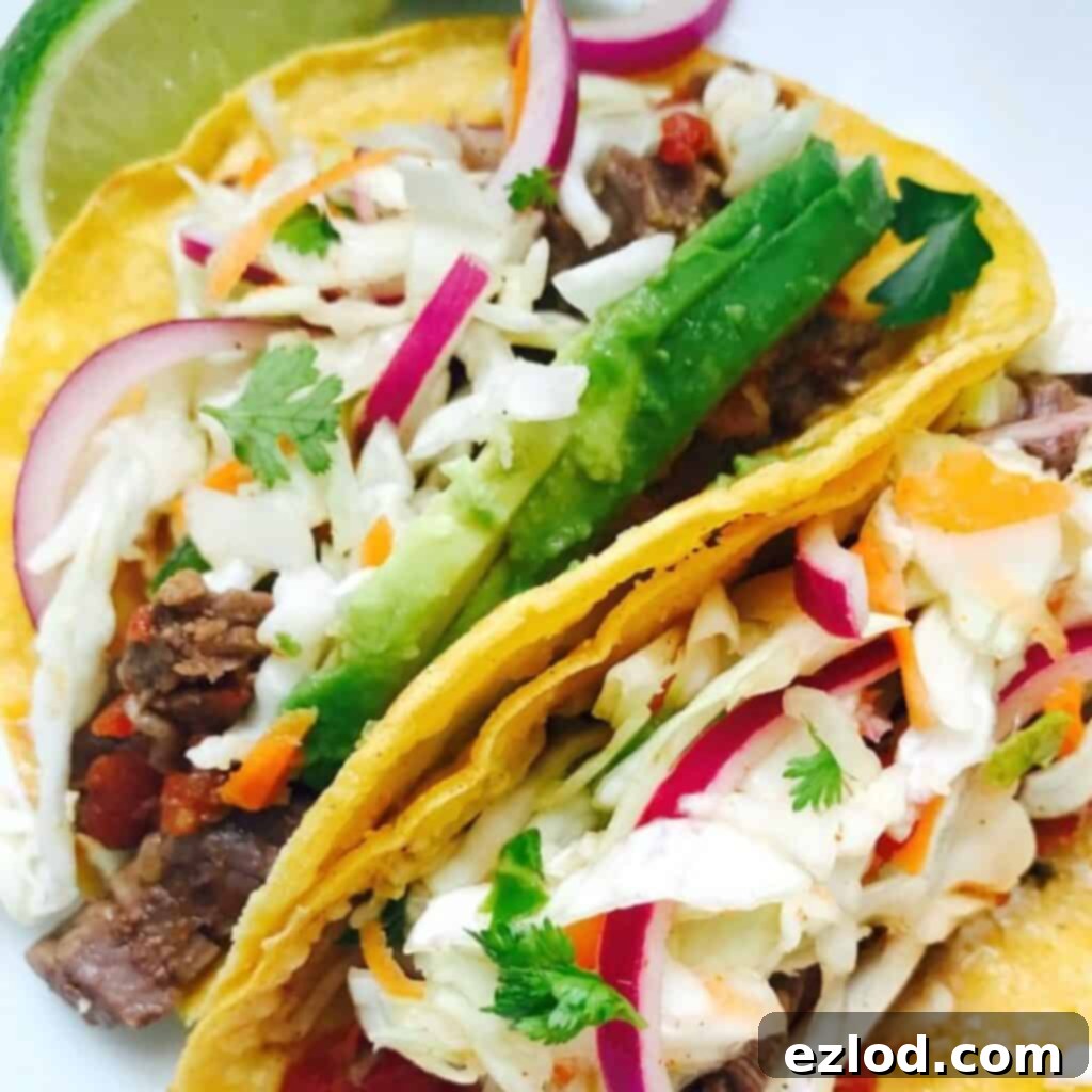 Close up of two flank steak tacos with cilantro lime slaw in corn tortillas.