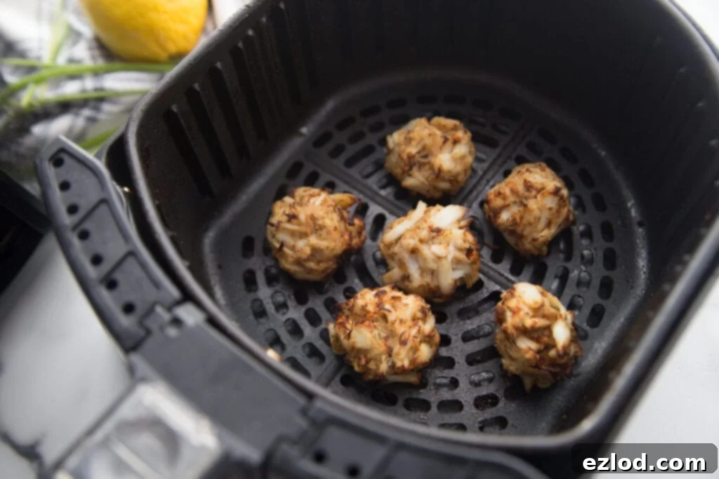 Air fryer basket with mini crab cakes that are gluten free
