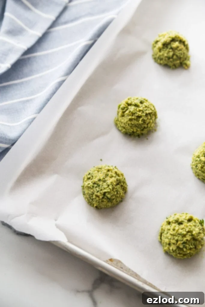 Parchment lined sheet pan with rows of Easy Falafel Bites ready to be cooked